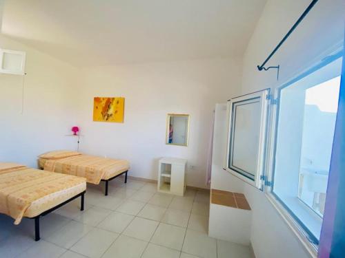莱乌卡Casa Vacanze Sofimar con Trullo的客房设有两张床和窗户。