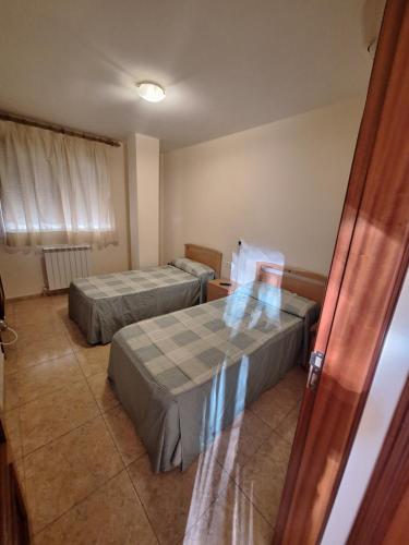 TardientaHostal Pension - La Rotonda的客房设有两张床和窗户。