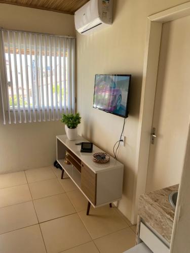 伊塔帕里卡岛维拉克鲁兹Flat Beira Mar no Condomínio Diver的客厅的墙上配有电视