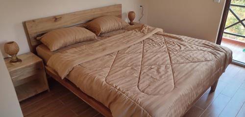 Phumĭ Chroŭy SvayCare Rock Guesthouse的卧室内的一张大床,配有木制床头板