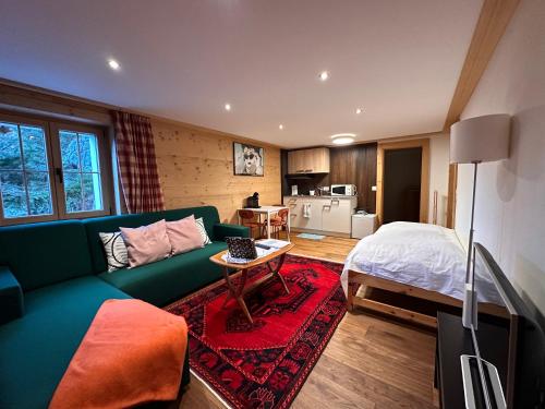 茨韦西门One Bedroom with mountain and garden view ground floor of Chalet Solaria的客厅配有绿色沙发和床。