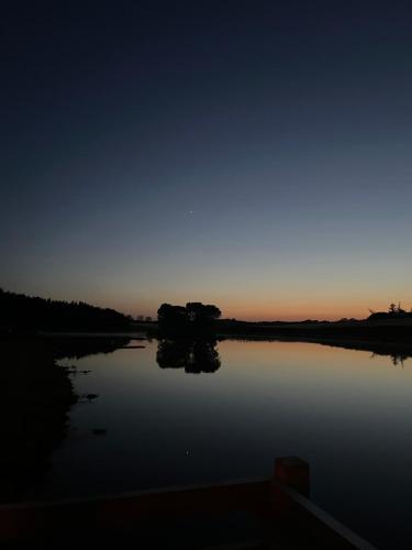 Cornhill-on-tweedEast Learmouth Lakeside Lodges的享有夜间湖景和阳光