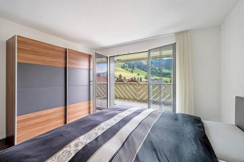 Oberiberghelle moderne 3,5-Zimmer-Wohnung 84m2的一间卧室设有一张大床和一个大窗户
