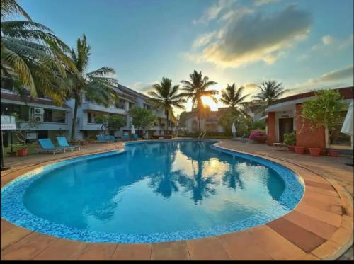 巴加Riveria Foothills & Residency Apartments的棕榈树度假村内的游泳池