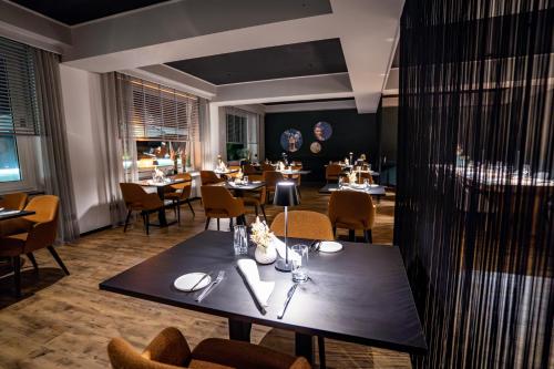 博帕德兰德卡斯福里特尔酒店的餐厅设有一张黑桌子、椅子、桌子和桌面