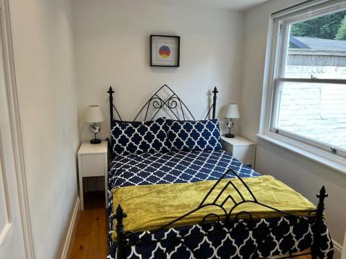 切辛顿Lovely Annexe near Surbiton/Kingston, SW London的一间卧室配有一张蓝色和黄色的被子
