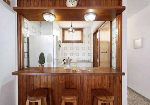 坎德拉里亚Costa Azul apartamento con vista的厨房配有带凳子的柜台和冰箱。