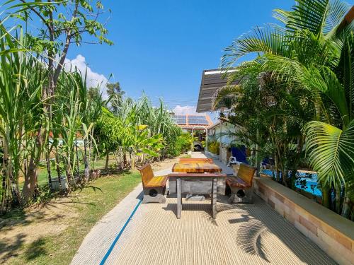 罗勇Tina's Living Paradise II - Guesthouses with private pool, 5 min to beach的树荫步道上的桌椅
