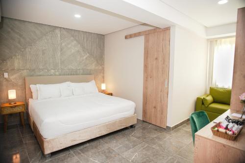 卡塔赫纳Bahía Boutique House的卧室配有白色的床和绿色椅子