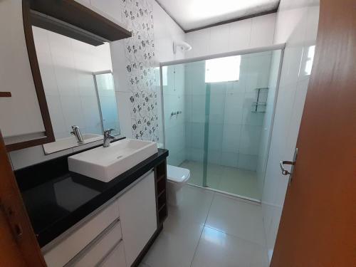 纳韦甘蒂斯Casa a 200 mts da praia - prox Aeroporto NVG - CASA DA MEIA PRAIA的一间带水槽和玻璃淋浴的浴室
