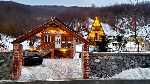 Gropat e SelcësVilat Pllumaj的雪中的房子,前面有停车位