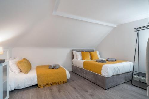 伦敦Cosy 4th Floor studio apartment in Brick Lane的配有白色墙壁和木地板的客房内的两张床