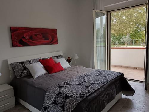 苏尔莫纳Parco delle Rose的一间卧室配有一张带红色枕头的大床