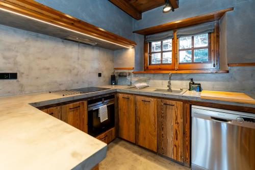 埃尔塔特Pleta del Tarter Lodge的厨房配有木制橱柜、水槽和洗碗机。