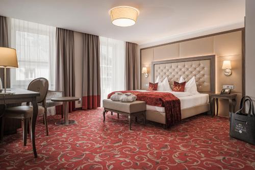 巴特霍夫加施泰因Hotel Norica - Thermenhotels Gastein mit dem Bademantel direkt in die Therme的配有一张床和一张书桌的酒店客房