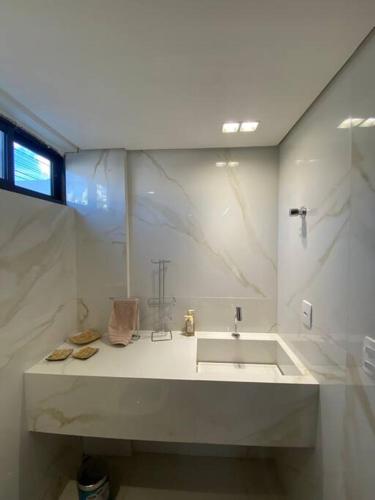卡贝德卢Bangalô na praia的白色的浴室设有水槽和窗户。