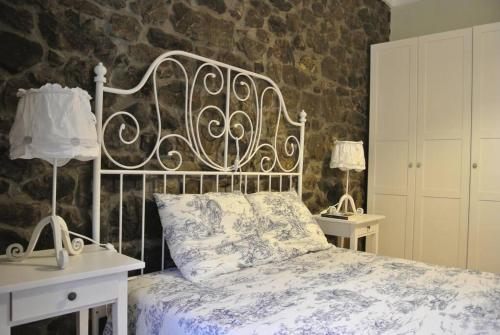 波拉·德莱纳La casa'l cantirín的一间卧室配有一张床、两张桌子和两盏灯。