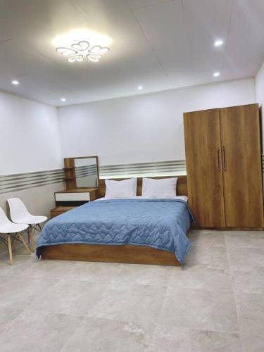芹苴T-House的一间卧室配有一张大床和木制橱柜。