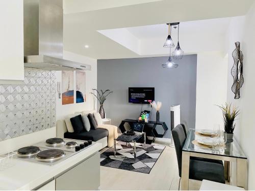 马尼拉The Bahamas and Maldives Suites at Azure Residences near Manila Airport的厨房以及带沙发和桌子的客厅。