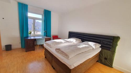 曼海姆Helles Zimmer mit Kingsize-Bett的一间卧室设有两张床、一张桌子和一个窗口。