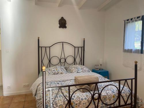 普罗旺斯艾克斯Superbe annAix de villa的一间卧室配有一张带锻铁床头板的床