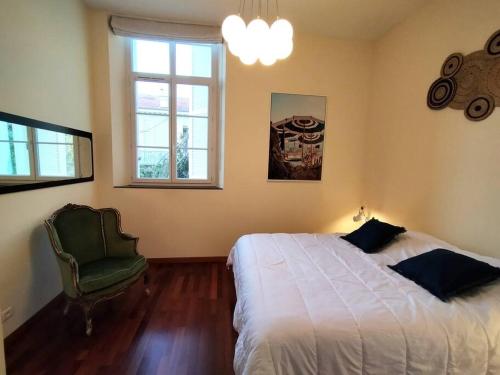 戛纳2 Bebrooms Duplex的卧室配有床、椅子和窗户。