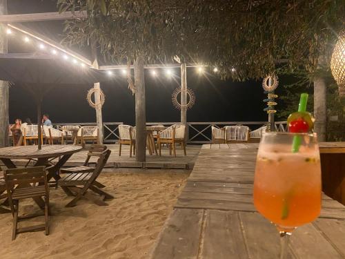 CamaronesMar Azul - Playa y Turismo的坐在餐厅前木桌边喝一杯
