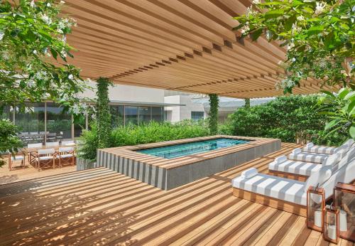 新加坡The Singapore EDITION的一个带游泳池的庭院,位于木制凉棚下