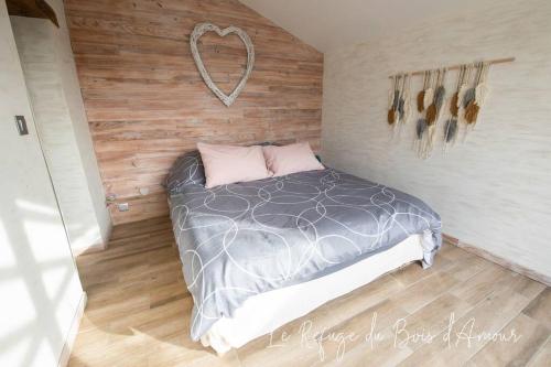 Arnières-sur-ItonLe Refuge du Bois d'Amour的卧室配有一张位于墙上的床铺。