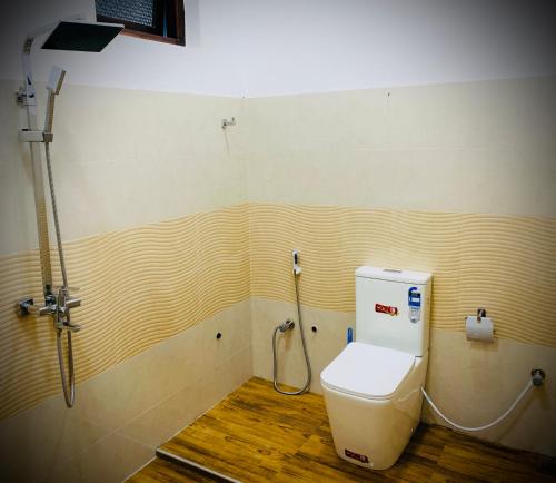 拜蒂克洛Villa Exora Pasikudha的一间带卫生间和软管的浴室