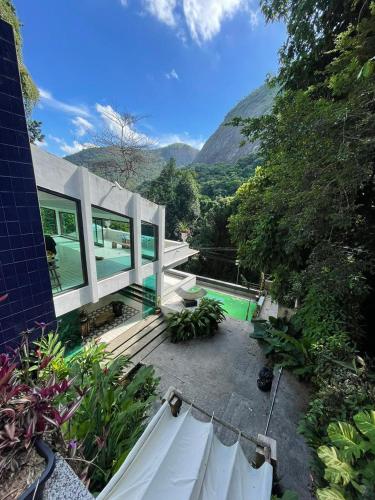 里约热内卢Maison Ruibal的一座房子,后面设有游泳池和山脉