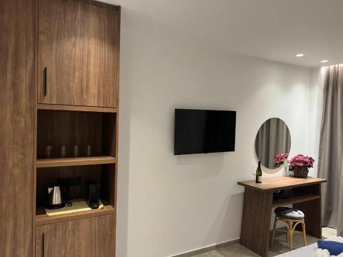阿凡杜Johannes Boutique Apartments & Suites的一间设有一张桌子的墙上电视的房间
