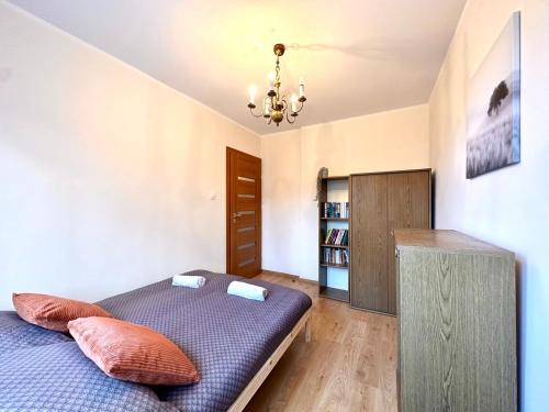 索波特MMRent Przytulny apartament w Sopocie的一间卧室配有一张床和一个吊灯