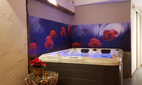 Les Portes du CoglaisMaison d'hôte avec sauna et jacuzzi à la campagne的浴室设有蓝色墙壁和按摩浴缸。