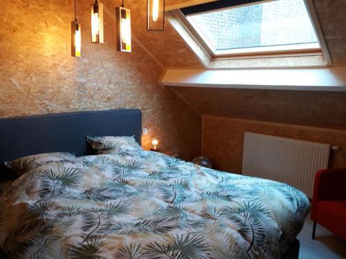 迪南Couque cuivrée II的一间卧室配有一张蓝色的床和窗户