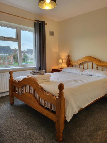 BallysheedyGreenview的一间卧室设有一张大型木床和一个窗户。
