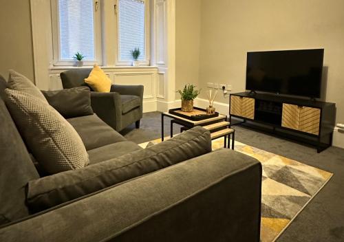 格拉斯哥Trendy West End Apartment, Glasgow的客厅配有2张沙发和1台平面电视