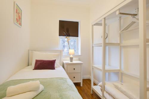 罗姆福特Beautiful Two Bedroom Apartment with Free Parking!的一间卧室设有一张床和一个书架