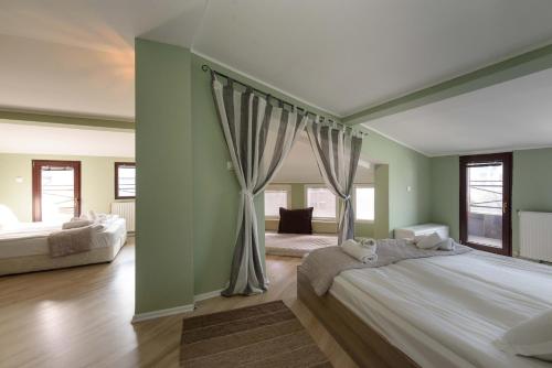 班斯科Villa Kaja Bansko的大卧室配有带窗帘的大床