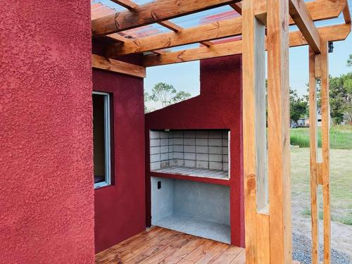 德尔迪阿布罗角Hermoso Monoambiente En Punta Del Diablo - Rocha的红色的房子,设有红色的墙壁和木门廊