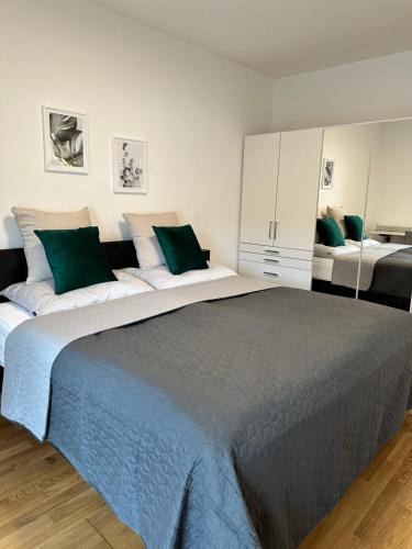 拉斯尼茨霍Harmony Living - 10 min to Graz的一间卧室配有一张带绿色枕头的大床