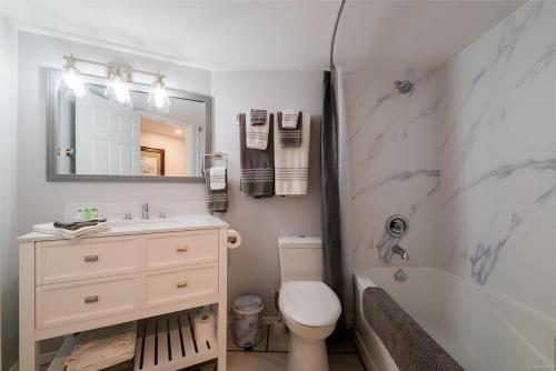 莱迪史密斯Trails End Beach house suite w/hot tub的浴室配有盥洗盆、卫生间和浴缸。