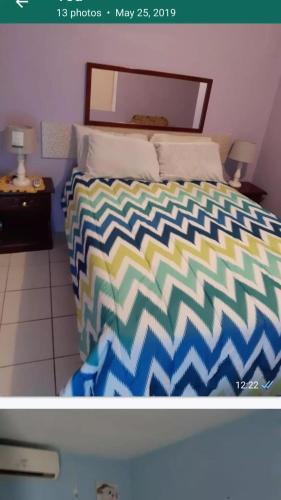 Beverly HillsThe Cliff Apartments的一间卧室配有一张带五颜六色棉被的床