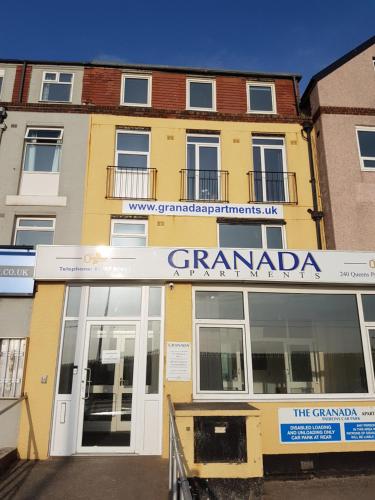 布莱克浦Granada Apartments Queen's Promenade的黄色的建筑,上面有读祖母的标志