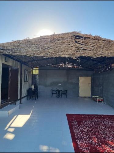 Madain Salehنزل ريفي的大房间设有屋顶、桌子和地毯