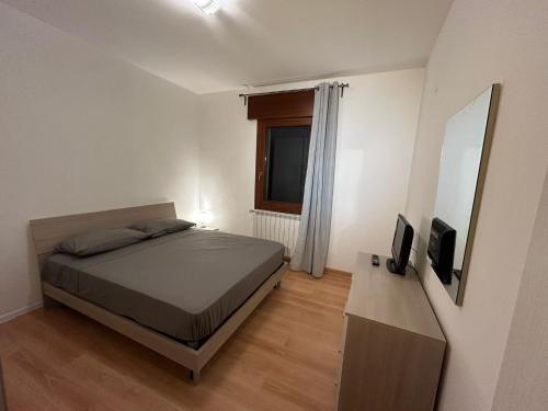 基奥贾Clodia Skyline的一间卧室配有一张床、一台电视和一面镜子
