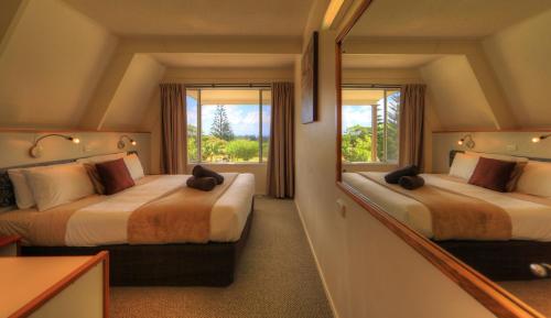 彭特派因莫库图A字形小屋的酒店客房,设有两张床和镜子