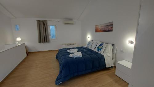 切法卢Marina House的一间卧室配有一张带蓝色毯子的床