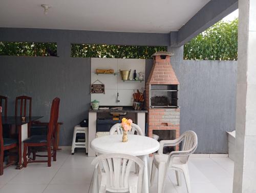 盖比姆Praia Guaibim的庭院配有桌椅和砖炉