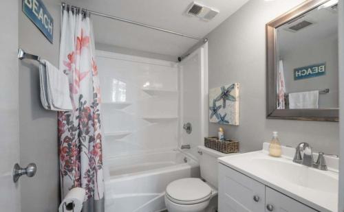 默特尔比奇Two Bedroom Apartment at the Palace Resort的白色的浴室设有水槽、卫生间和浴缸。